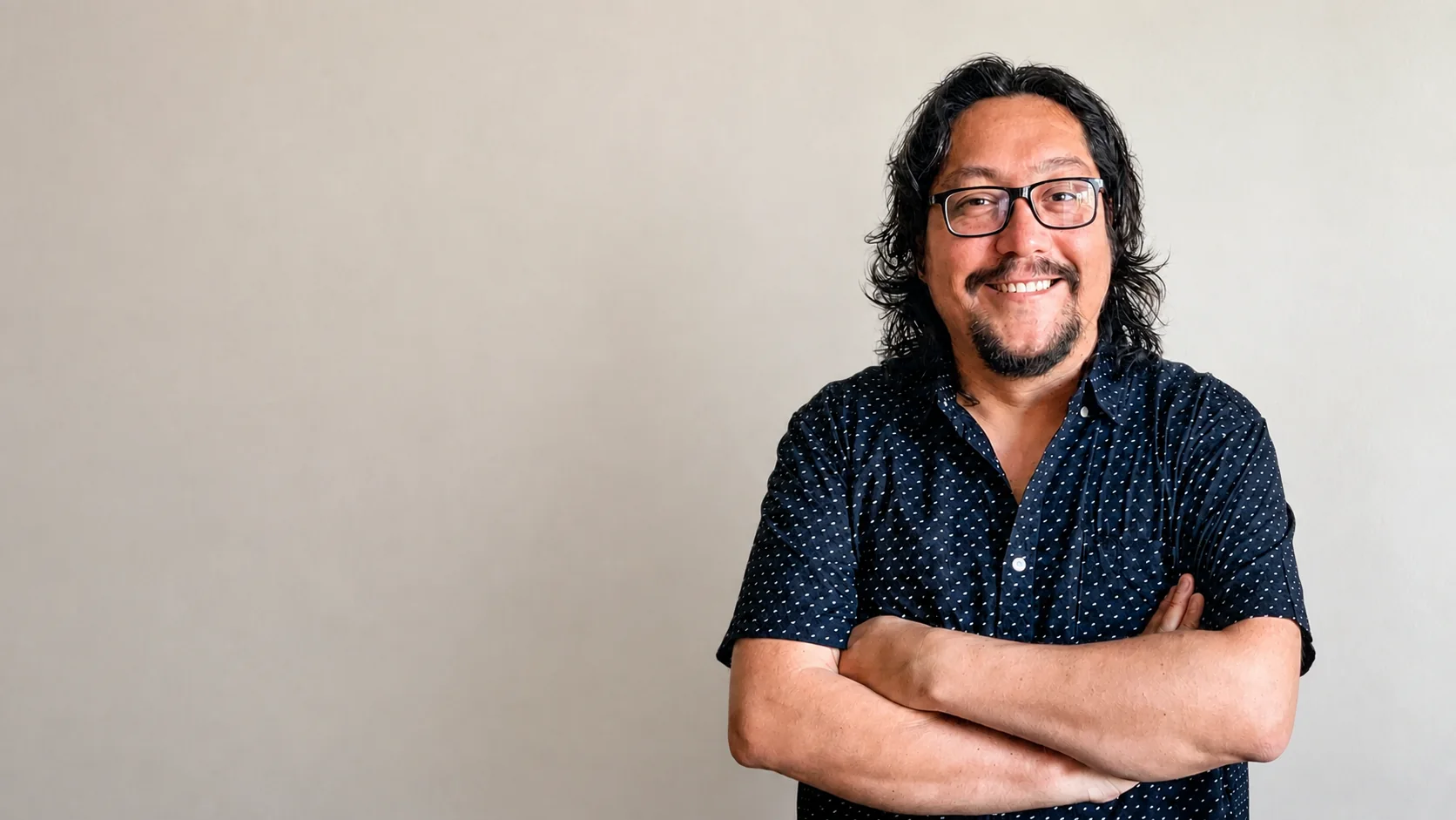 César Céspede, diseñador de producto, de brazos cruzados sobre un fondo liso